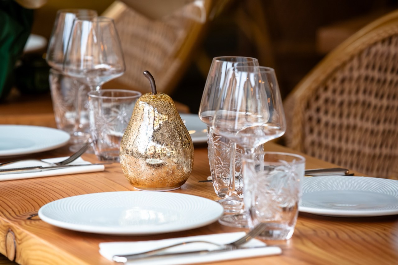 Table dressée en terrasse avec poire dorée et verres